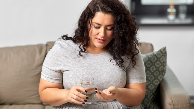 woman taking CBD pill