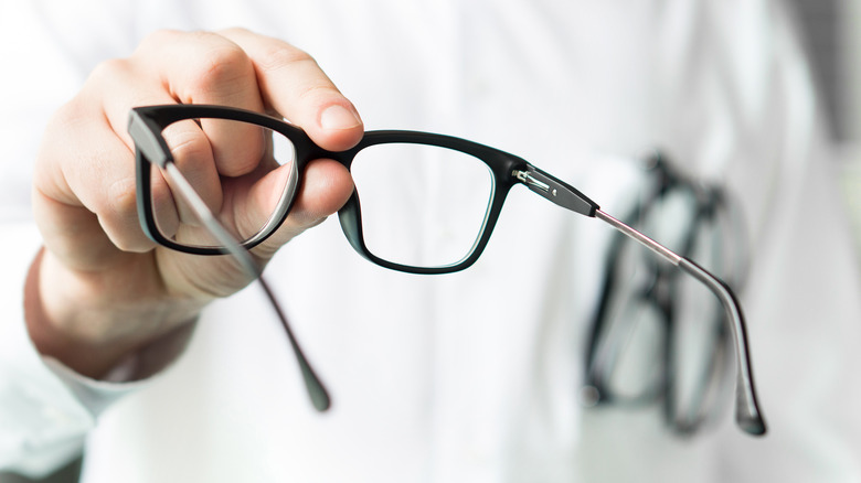 person holding pair of eyeglasses