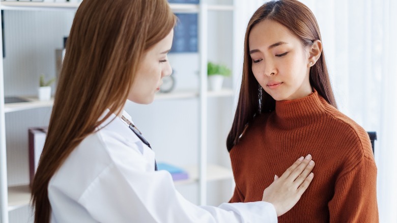 doctor with hand over woman's breast