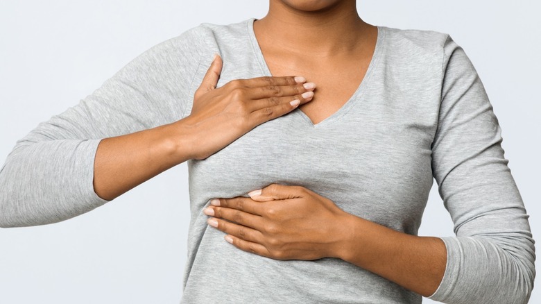 woman checking breast for lump