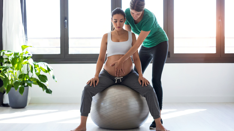 pregnant woman sitting on yoga ball