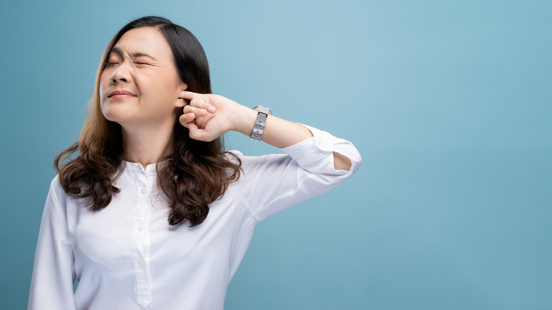 woman itches her ear