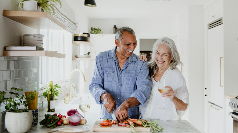 elderly couple cooking in kitchn