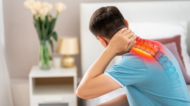 Man putting hand on neck