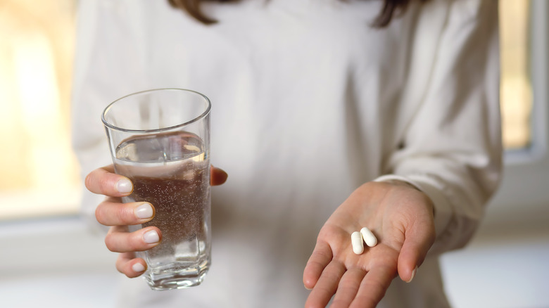 woman holding two pills