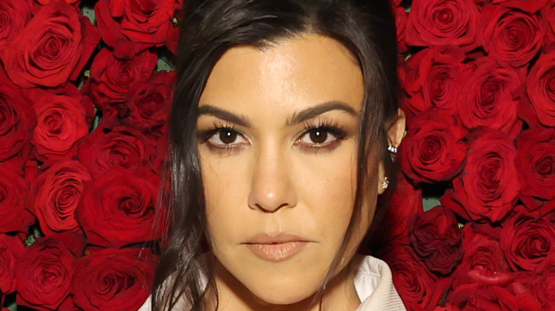 Kourtney Kardashian against background of roses