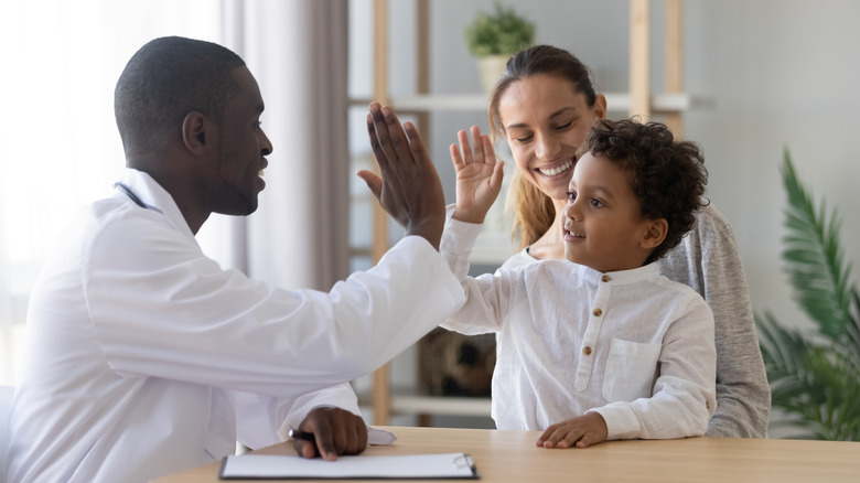 doctor high fives a little boy