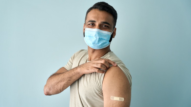 Masked man with bandage on arm