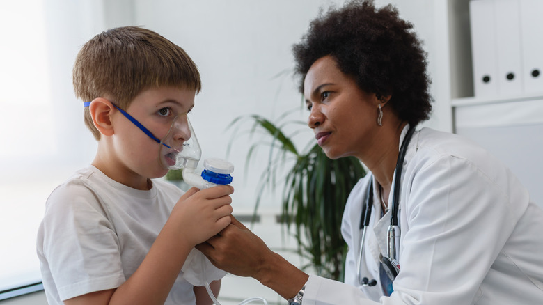 Doctor giving breathing support to child