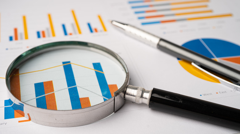 Magnifying glass over a series of bar graphs