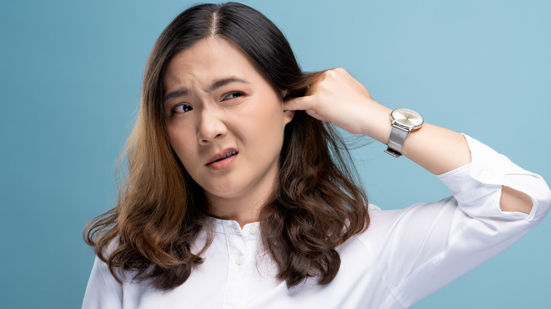 Woman sticking finger in ear