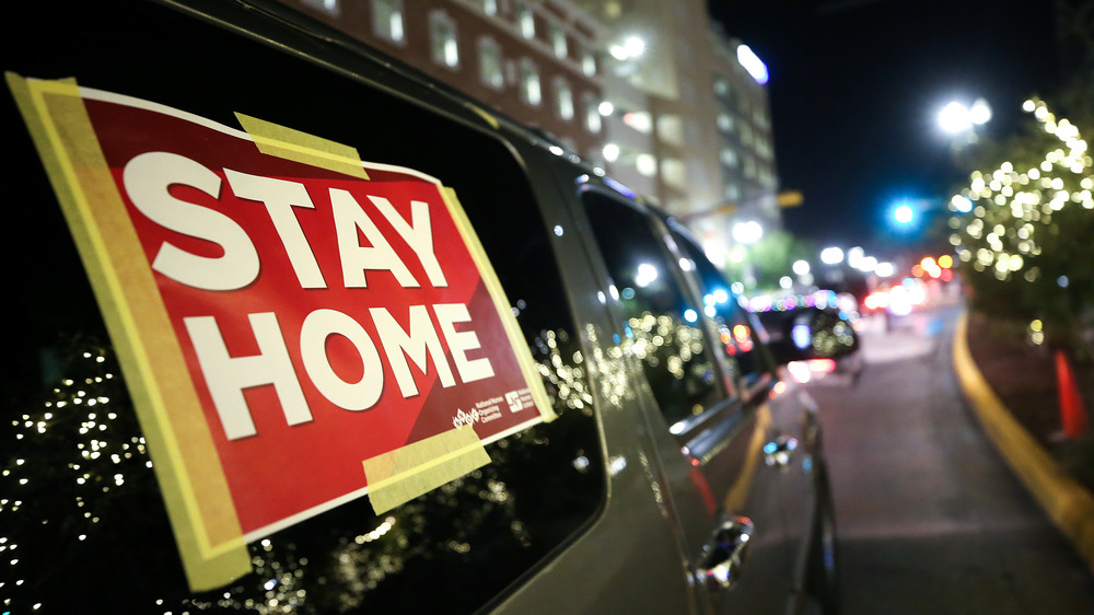 Closeup of a sign on a car in El Paso, Texas, urging people to stay home amid the COVID-19 surge