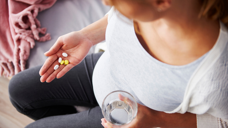 Pregnant woman holding vitamins