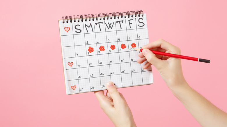 Woman holding a calendar to track her menstrual cycle