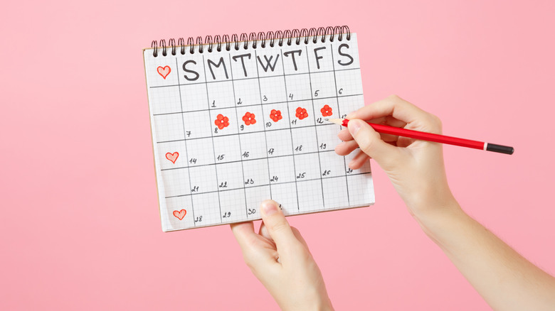 Woman holding a calendar to track her menstrual cycle