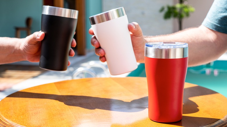 Three colorful Stanley tumblers above table