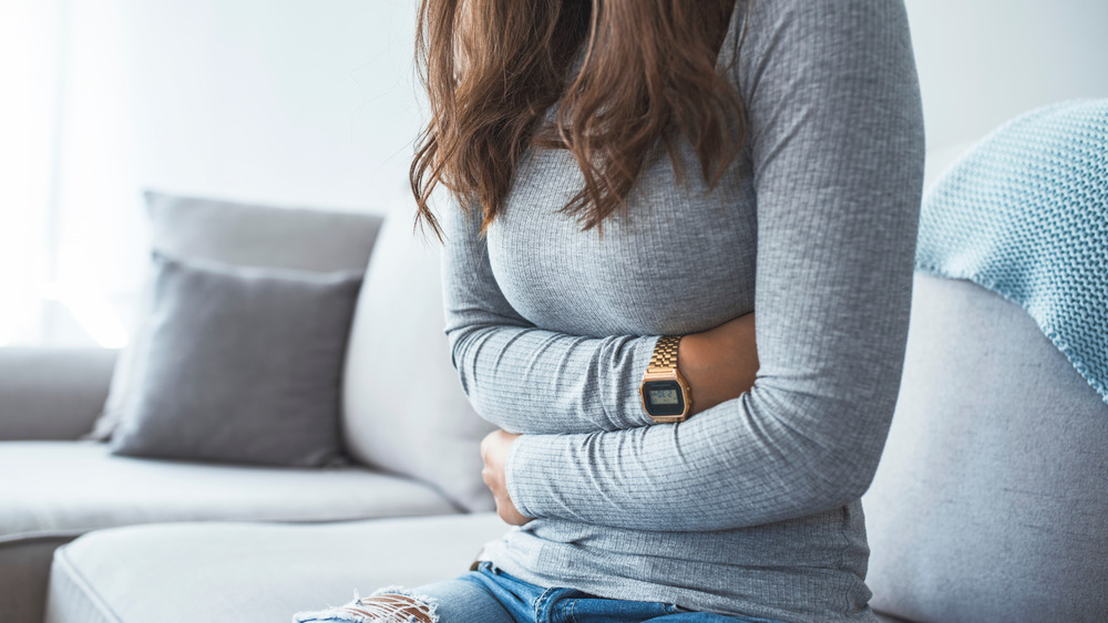 woman clutching stomach in pain