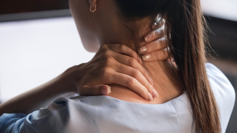 woman rubbing stiff neck