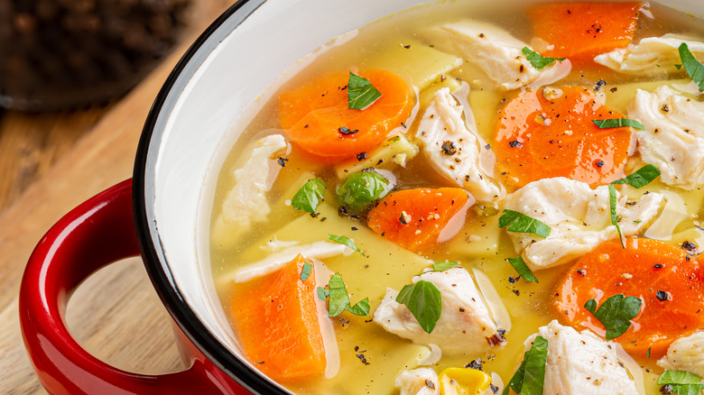 red crockpot full of chicken noodle soup 
