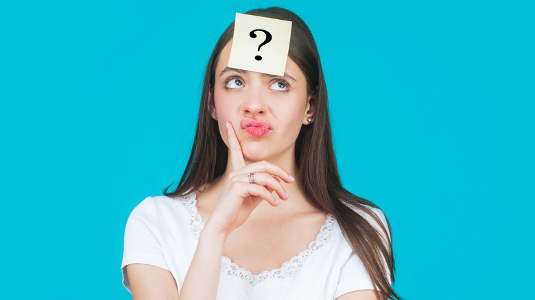 woman pursing lips question mark on forehead