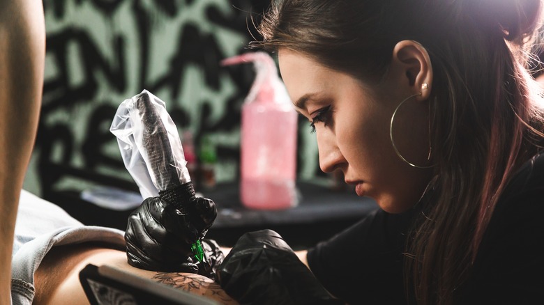A tattoo artist applying a tattoo