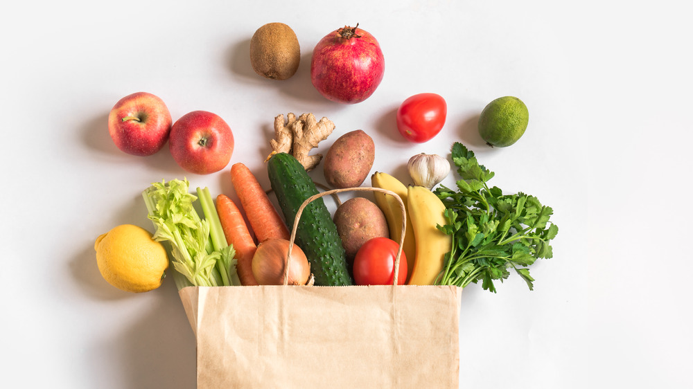 brown grocery bag spilling over with healthy foods 