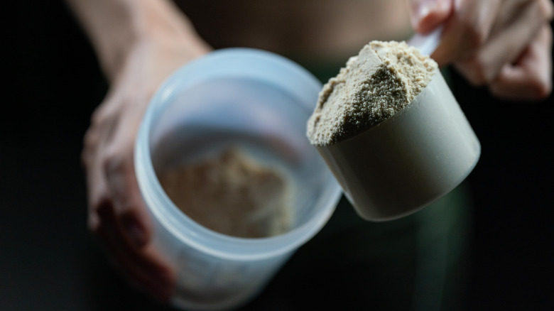 close-up of whey protein powder pouring into shaker bottle