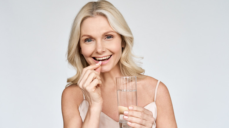 Woman taking supplement pill