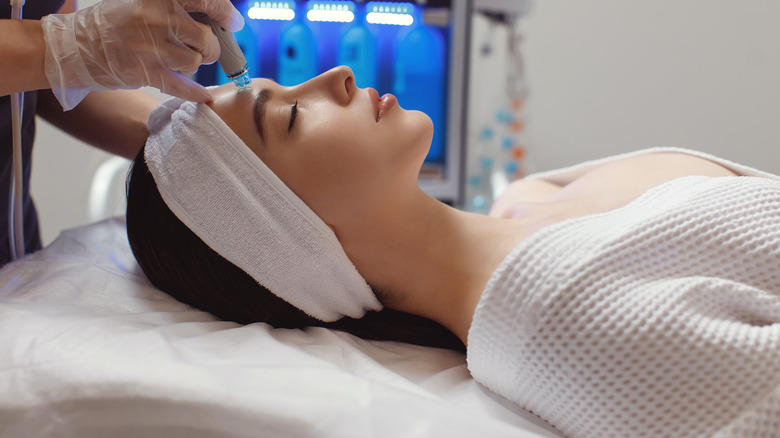 A close-up of a woman's face during laser treatment