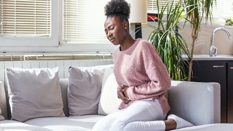 Woman holding stomach in pain