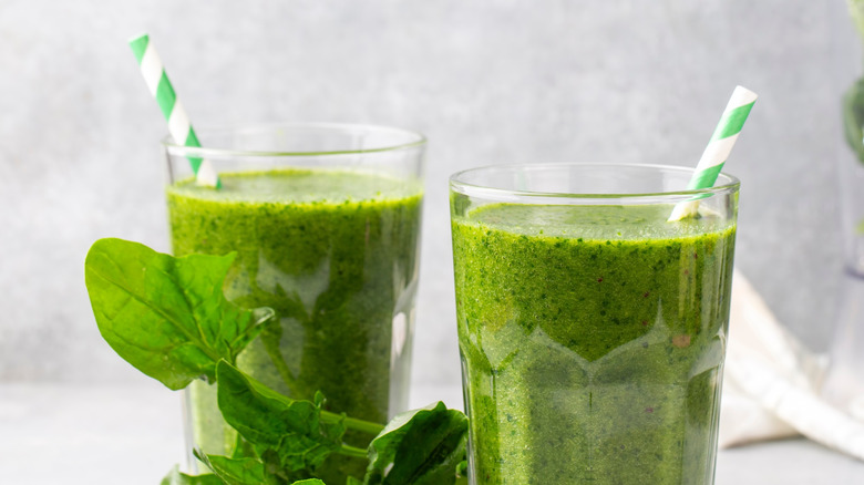 Green smoothies in glasses with paper straws