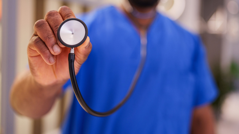 medical staff member holding stethoscope