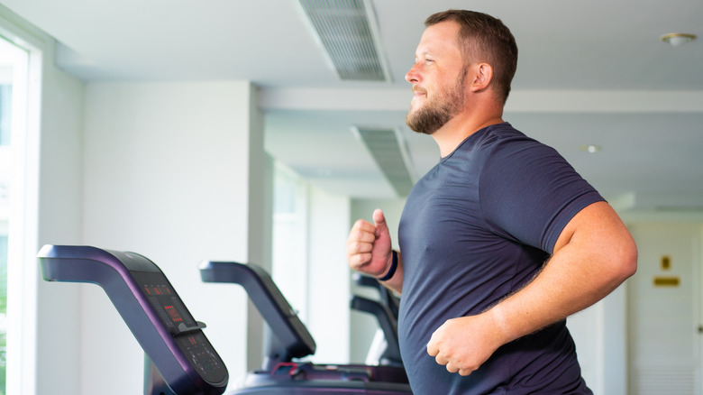 man running on treadmill in gym