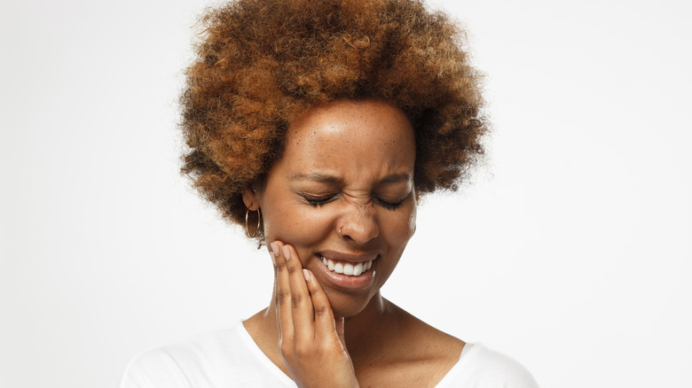 Woman holding jaw in pain