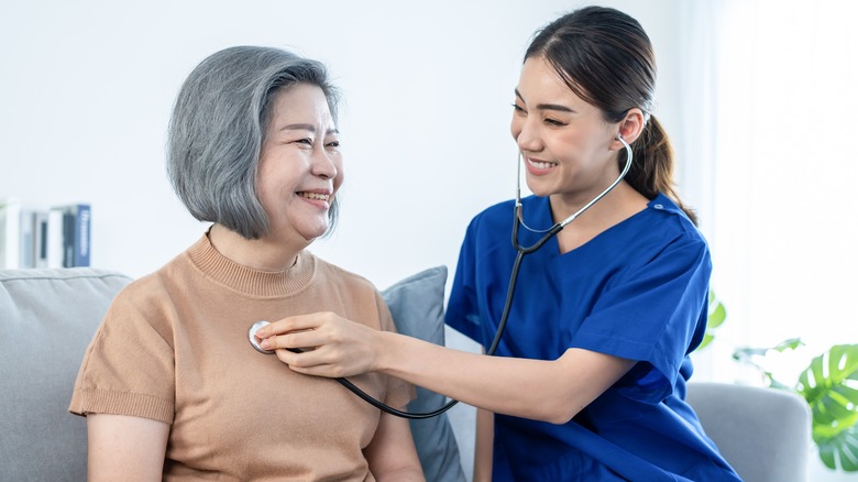 Nurse listening to patient's heart