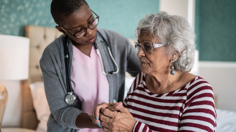 nurse comforting older woman