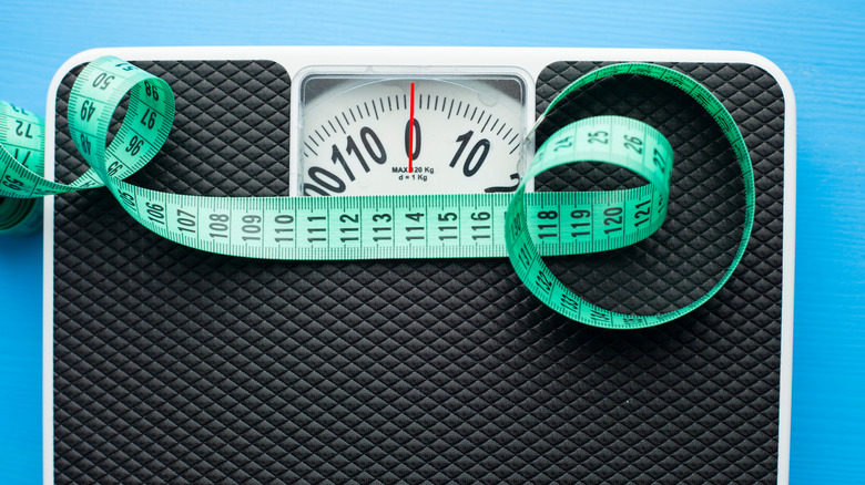 a scale with a green measuring tape on top 