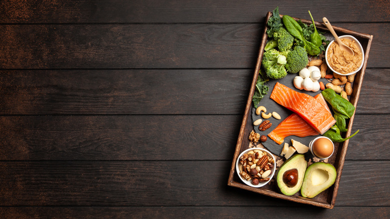 A tray of vegetables, salmon, eggs, and other low-carb foods