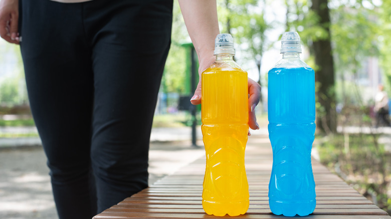 Hand grabbing two electrolyte drinks