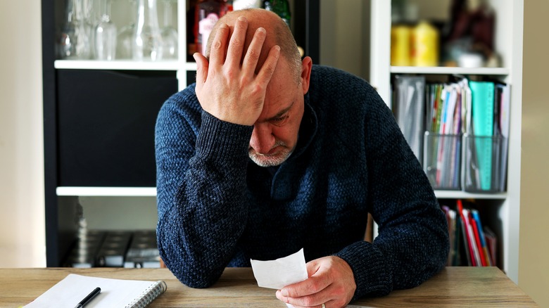 Stressed man looking at papers