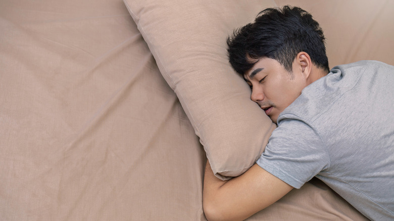 Man sleeping on stomach in bed