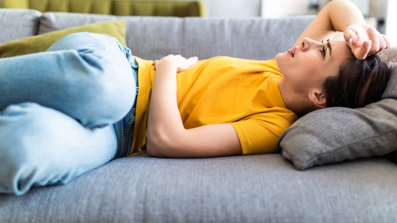 Woman lying on back holding stomach