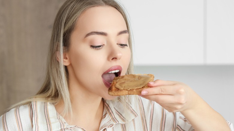Woman eating bread with peanut butter