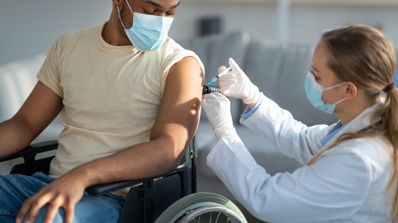 man in wheelchair getting vaccinated