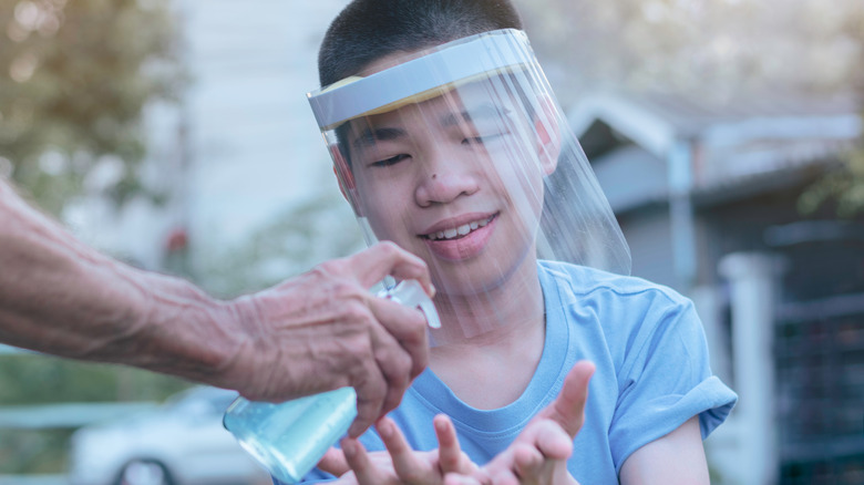 smiling boy getting hand sanitizer