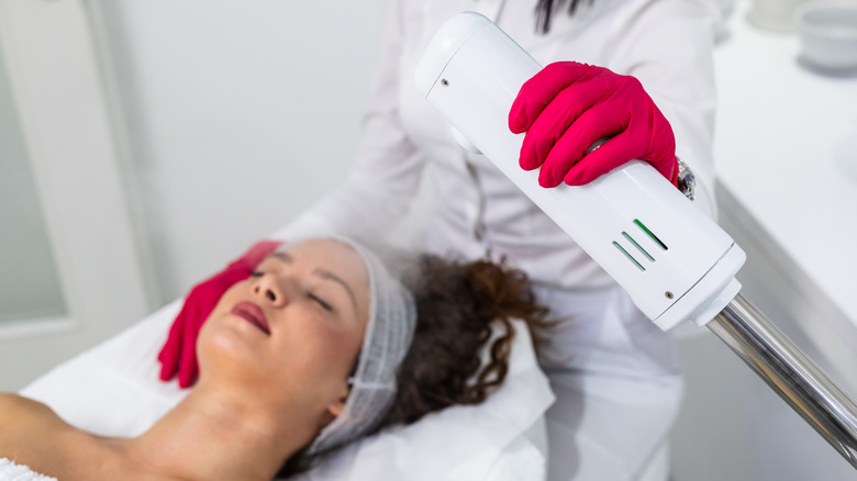 Woman receiving facial steam treatment 