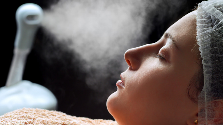 Woman receiving facial steam treatment