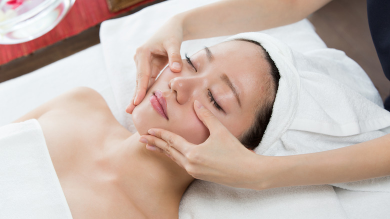 Asian woman receiving facial treatment