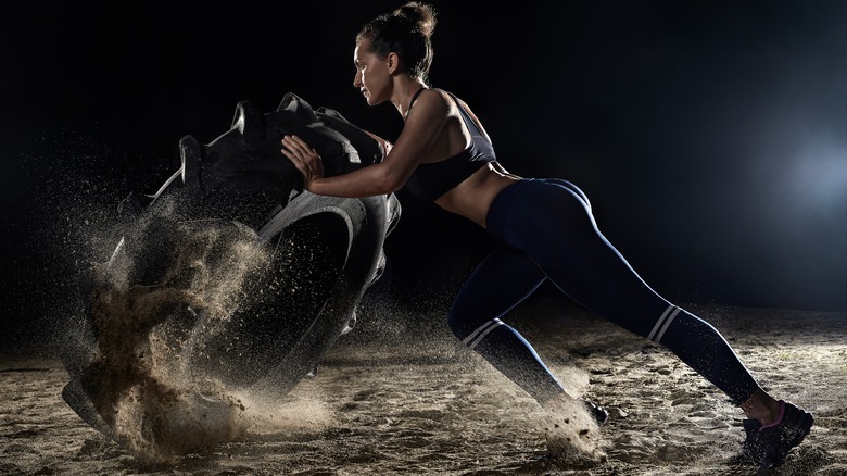 Woman turning over tire