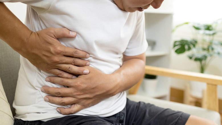 man holding side of abdomen